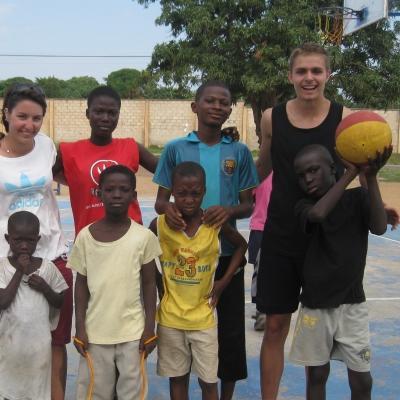 Volunteer basketball coaches in Ghana pose with players Projects Abroad volunteers teach basketball in Ghana to a group of children